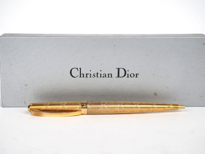 CHRISTIAN DIOR. Stylo à bille en métal plaqué dans son coffret. Signé.
