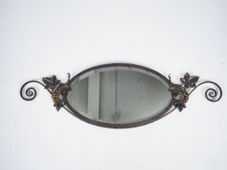 Vente aux enchères 	Glace ovale Art Déco en fer forgé à décor de pampres. Dim. 132 x 43,5