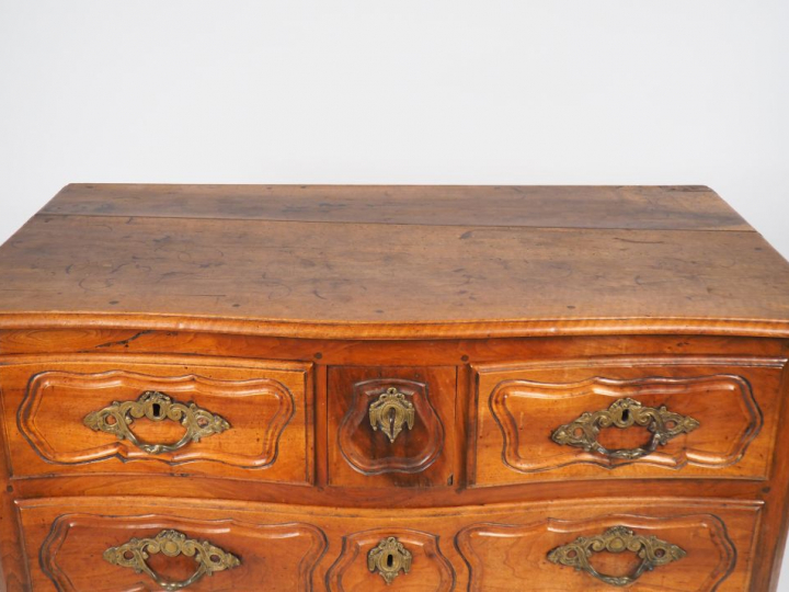 Commode XVIIIème en noyer mouluré et sculpté, ornementation de bronze,