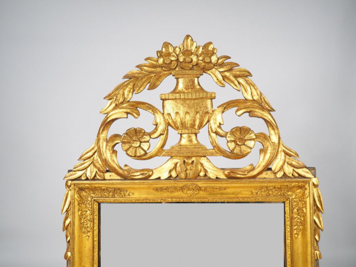 Glace XIXème de style Louis XVI en bois et stuc doré à décor de rincea