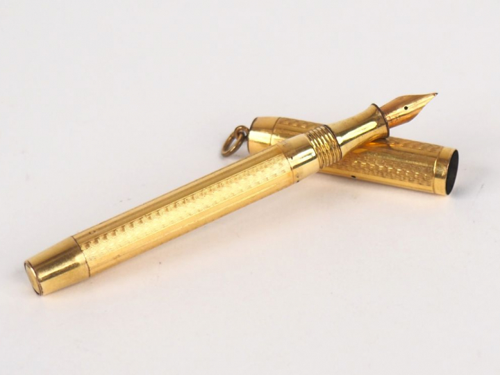 Stylo plume en métal doré et or. Poids tel. 11,7 g. L. 9 cm.   