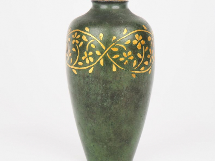 CHRISTOFLE. Soliflore ovoïde en bronze à patine verte à décor doré de 