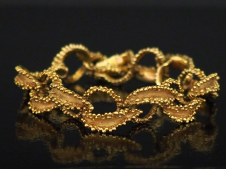 Vente aux enchères Bracelet articulé en or jaune, à décor ajouré d'entrelacs.  Long. 19 c