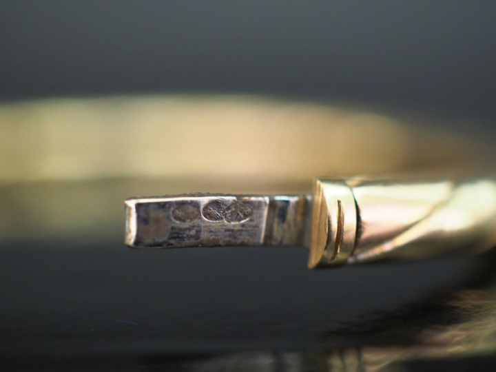 Bracelet jonc en or jaune, à décor gravé de côtes torses.  Fermoir lat