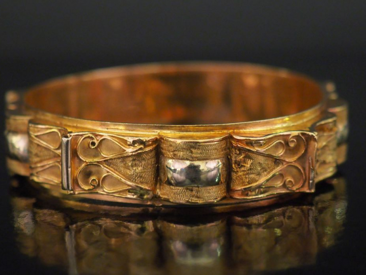 Bracelet jonc deux tons d'or, à décor mouvementé et filigrané.  Diam. 