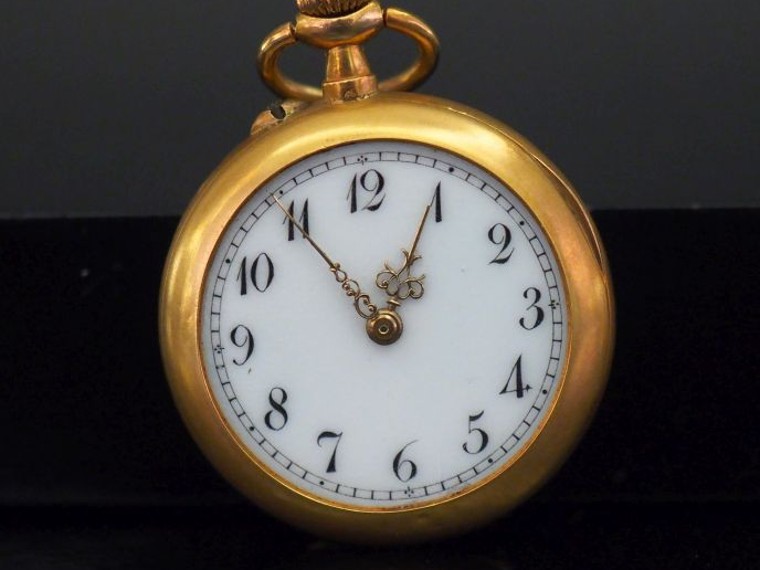 Montre de col en or jaune.  Cadran à chiffres arabes pour les heures. 
