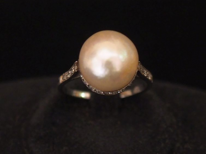 Bague en platine, sertie en son centre d'une perle retenue par une bas
