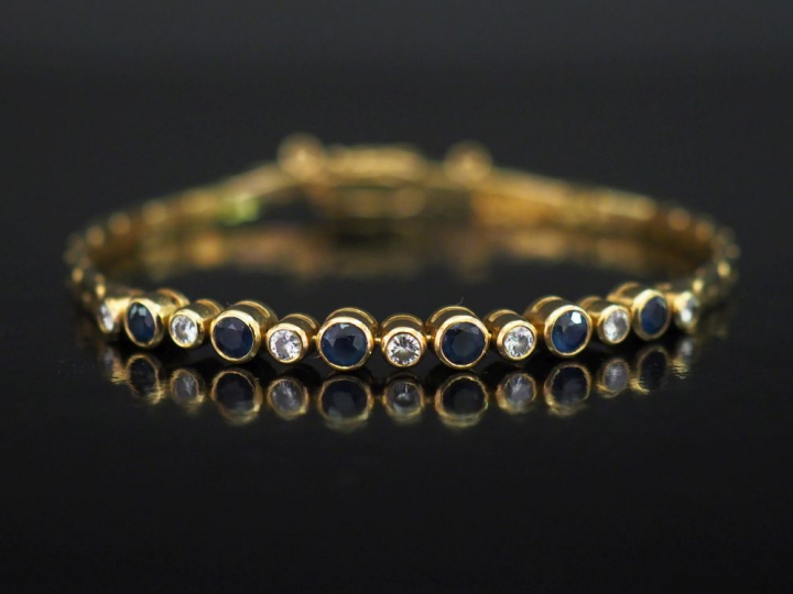 Bracelet souple en or jaune, maille haricot, serti en son centre de pe