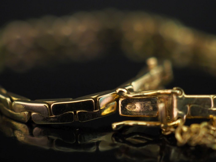 Bracelet souple en or jaune, maille haricot, serti en son centre de pe