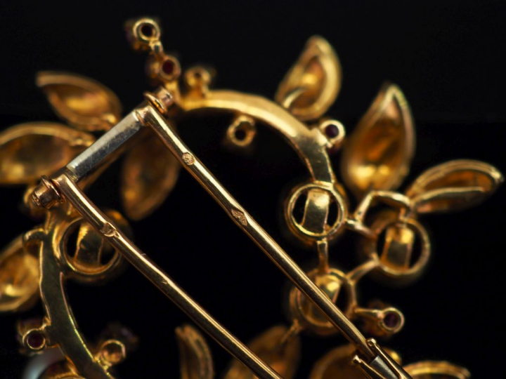 Broche ronde en or jaune, en forme de branchage fleuri, sertie d'une p