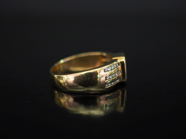 Bague moderne en or jaune, sertie en son centre d'une pierre bleue.  L