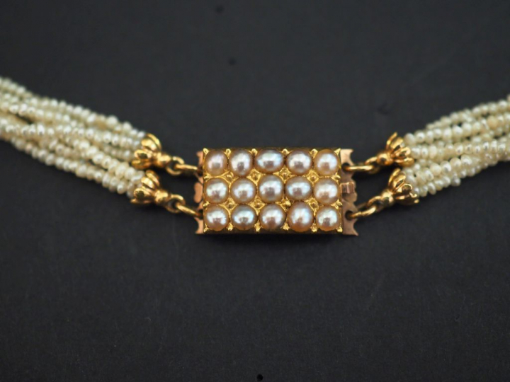 Collier de fines perles blanches composé de deux rangs à quatre brins.