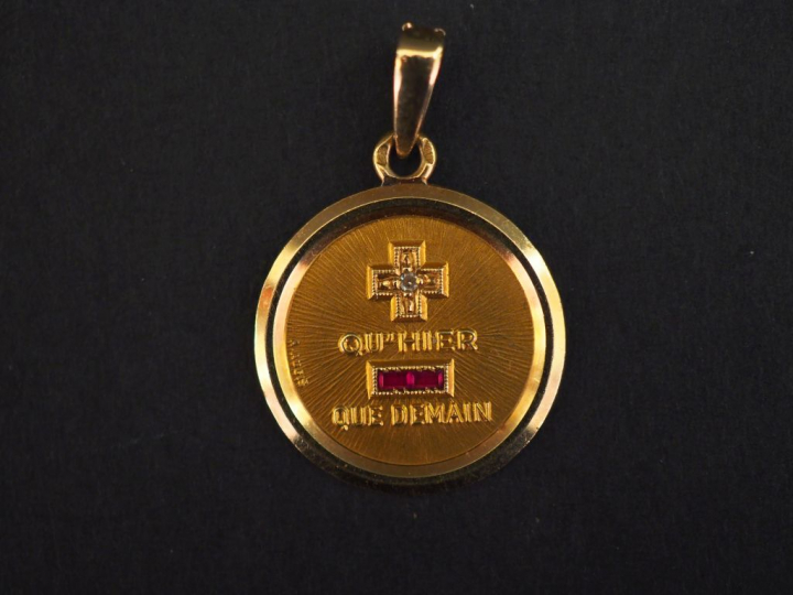 Médaille en or jaune, marquée " + qu'hier - que demain", agrémentée d'