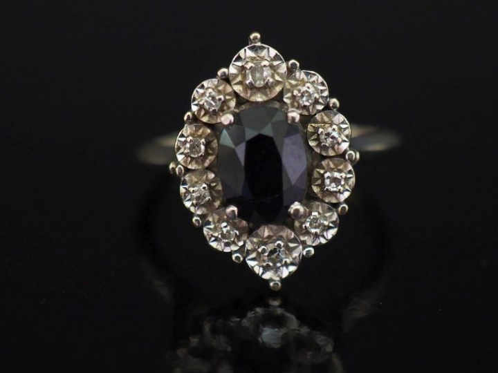 Bague de forme ovale en or blanc, sertie en son centre d'une pierre no