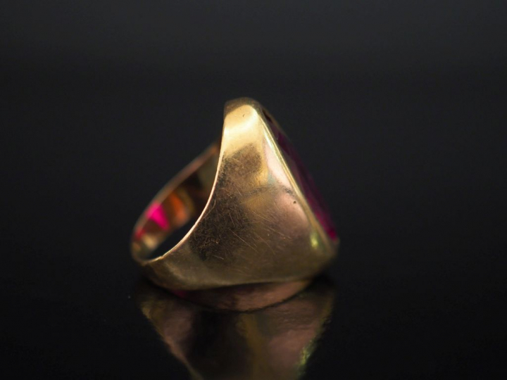 Bague en or jaune, sertie en son centre d'une pierre rouge de forme ma