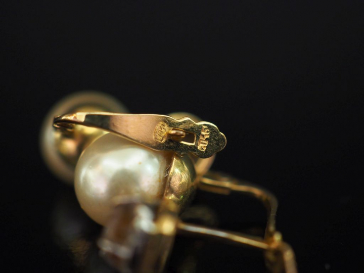 Paire de perces oreilles en or jaune, sertis d'une perle blanche surmo