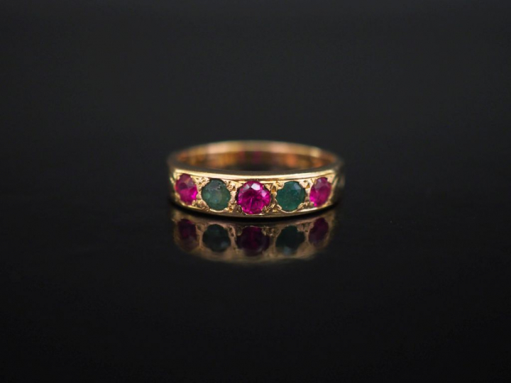 Bague jonc en or jaune, sertie d'une lignes de pierres vertes et roses