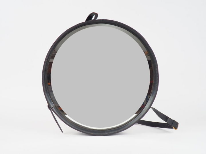 Miroir circulaire gainé de cuir noir. Diam. 45 cm