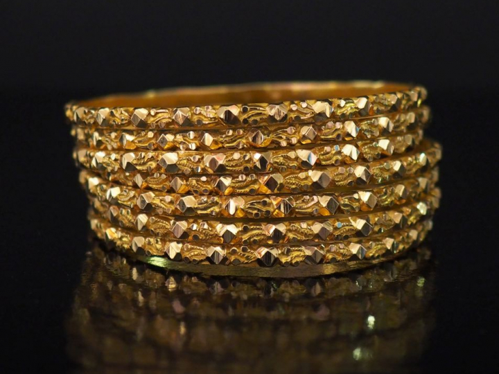 Sept joncs en or jaune formant semainier, à décort de motifs gémoétriq