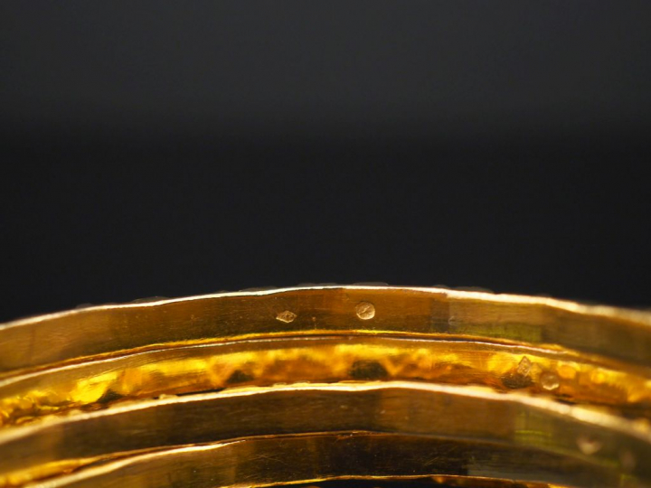 Sept joncs en or jaune formant semainier, à décort de motifs gémoétriq