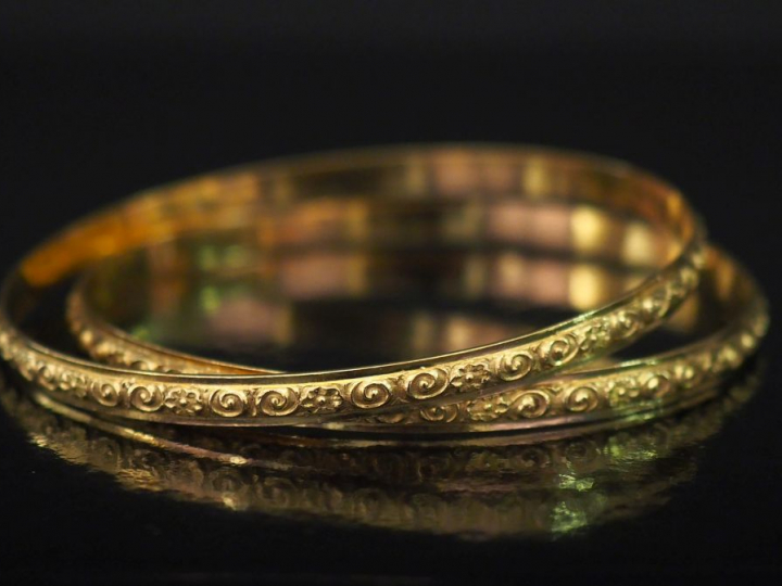 Paire de bracelets joncs en or jaune, à décor d'entrelacs et de fleurs