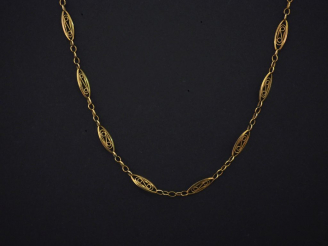 Vente aux enchères Collier souple en or jaune, à décor de maillons ajourés et filigranés.