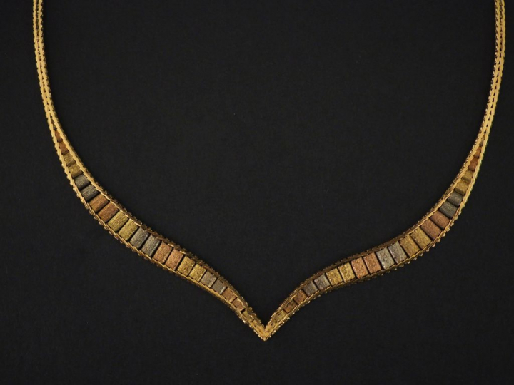 Collier articulé trois tons d'or, maille plate, se terminant en pointe