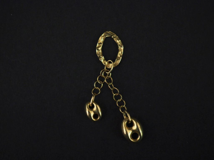 Pendentif en or jaune composé d'un motif ajouré et martelé de forme ov