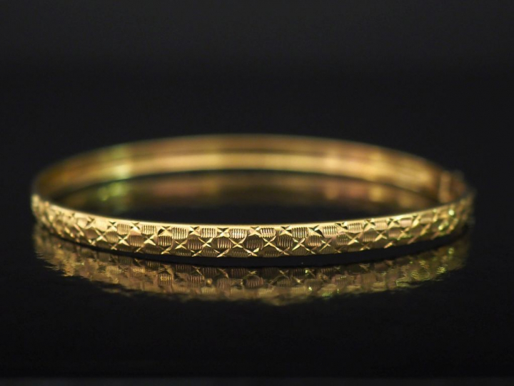 Bracelet jonc de forme ovale en or jaune, à décor de motifs géométriqu