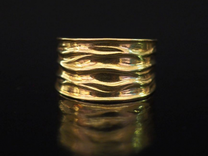 Bague bandeau en or jaune, à décor de cannelures mouvementées.  TDD. 5