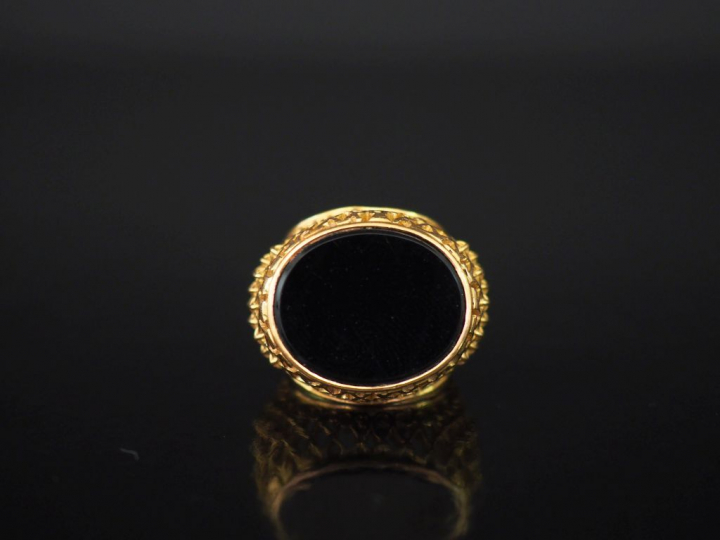 Importante bague en or jaune et onyx noir.  Jolie monture ajouré, à dé