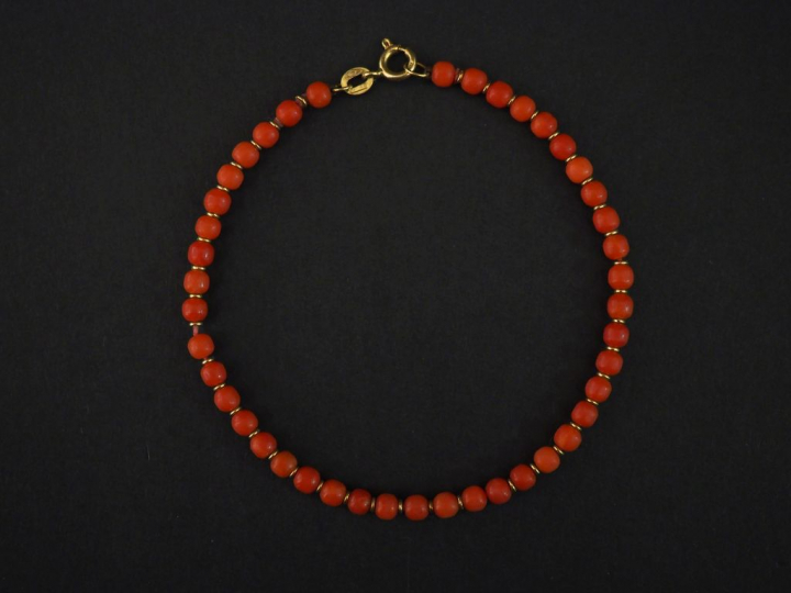 Bracelet en or jaune, orné de perles de corail. Long. 20 cm Poids tel.