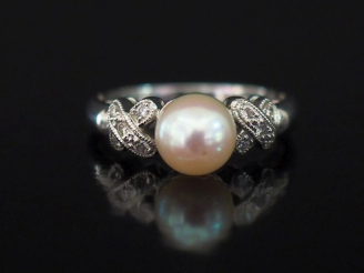 Vente aux enchères Bague en or blanc 750, sertie en son centre d'une perle blanche épaulé