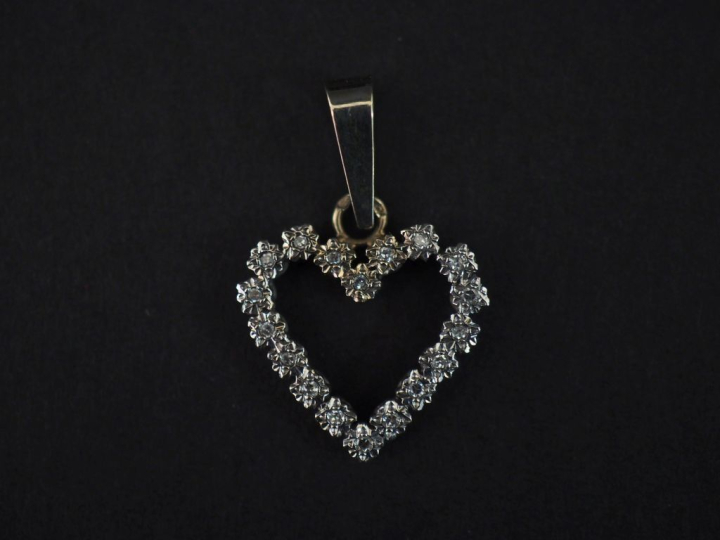 Pendentif en or blanc 750 en forme de cœur, serti de petits diamants. 