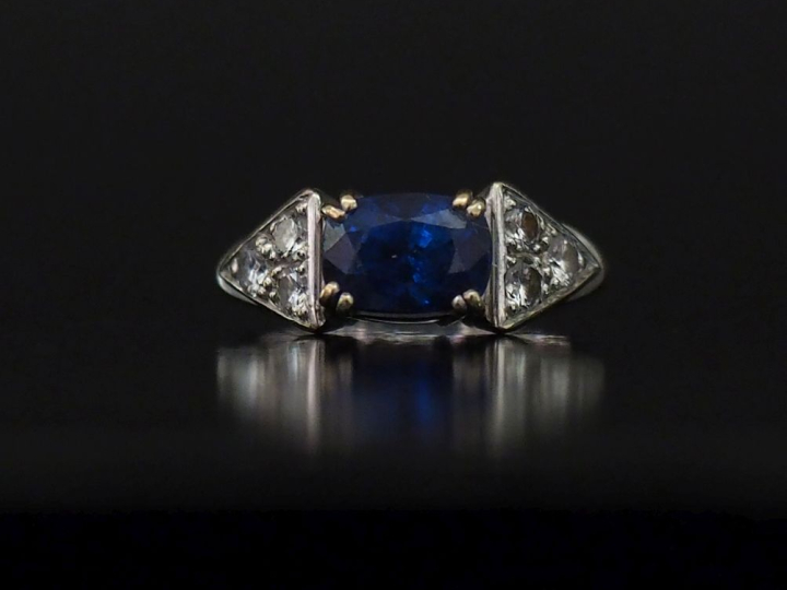 Bague en or blanc 750, sertie en son centre d'un saphir épaulé de part