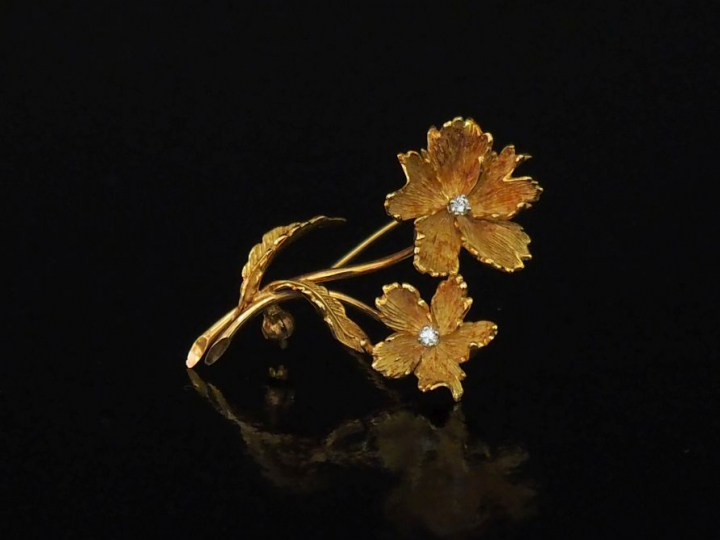 Broche en or jaune, en forme de fleurs, serties en leurs centres d'un 
