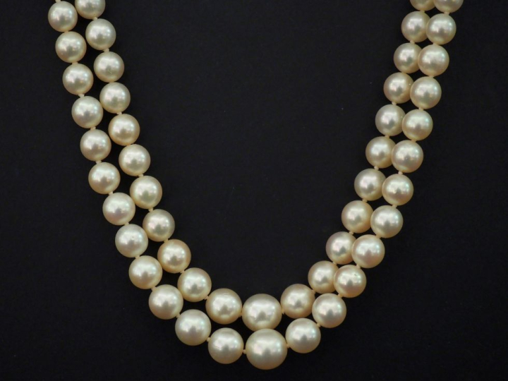 Collier double de rangs de perles blanches disposées en chute.  Joli f