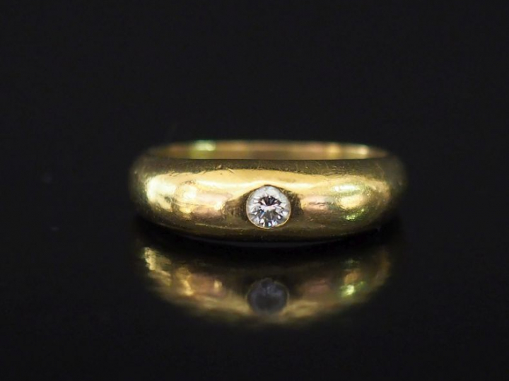 Bague jonc en or jaune, ornée en son centre d'un diamant serti clos de