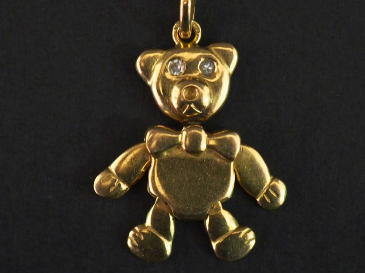 Pendentif en or jaune, figurant un ourson articulé au nœud papillon.  