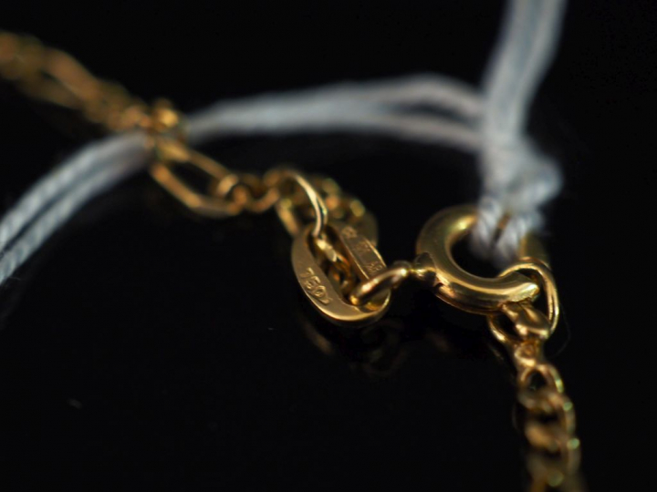 Collier en or jaune, maille figaro, orné en son centre d'une motif ajo