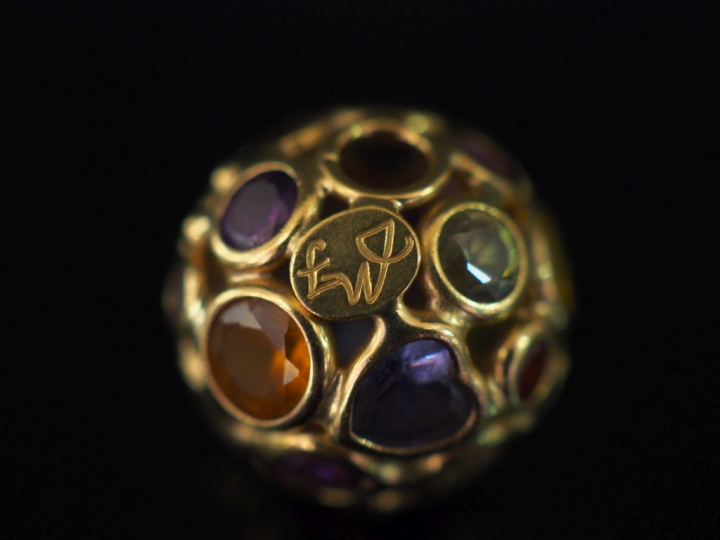 Pendentif rond en or jaune, à décor ajouré et agrémenté de pierres de 