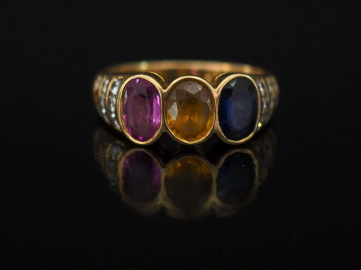 Bague jonc en or jaune, sertie en son centre de trois pierres de coule