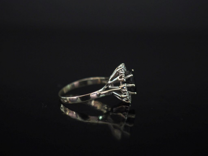 Bague de forme marguerite en or blanc, sertie en son centre d'un saphi