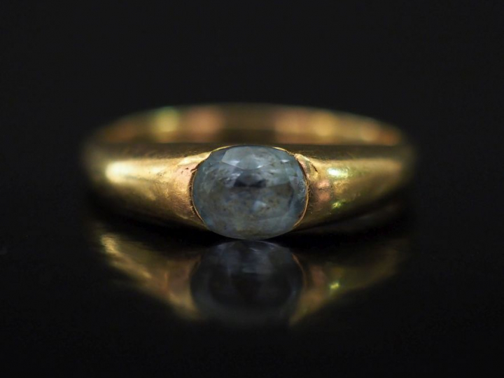 Bague jonc en or jaune, sertie en son centre d'une pierre bleu ciel. T