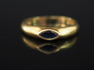 Vente aux enchères Bague jonc en or jaune, sertie en son centre d'une pierre bleue de for