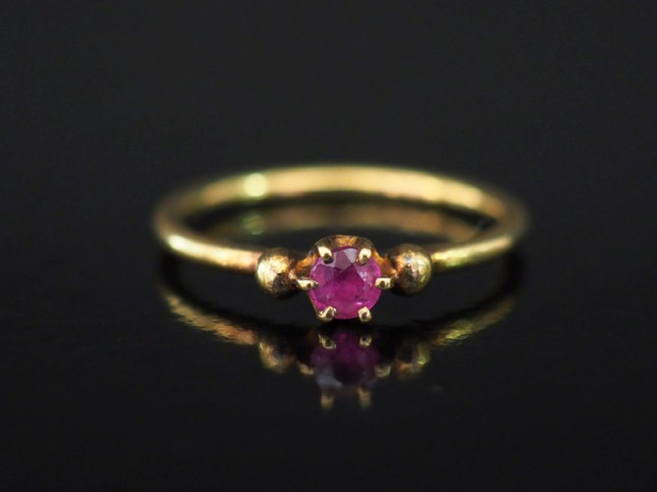 Petite bague en or jaune, sertie en son centre d'une pierre rose. TDD.