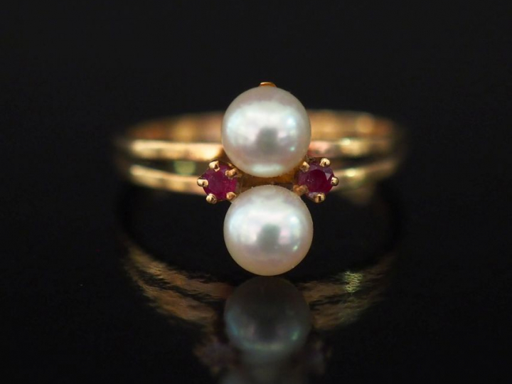 Bague en or jaune, sertie en son centre de deux perles blanches agréme