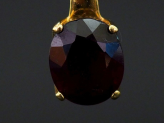 Vente aux enchères Pendentif en or jaune, serti en son centre d'une pierre rouge. H. 1,8 