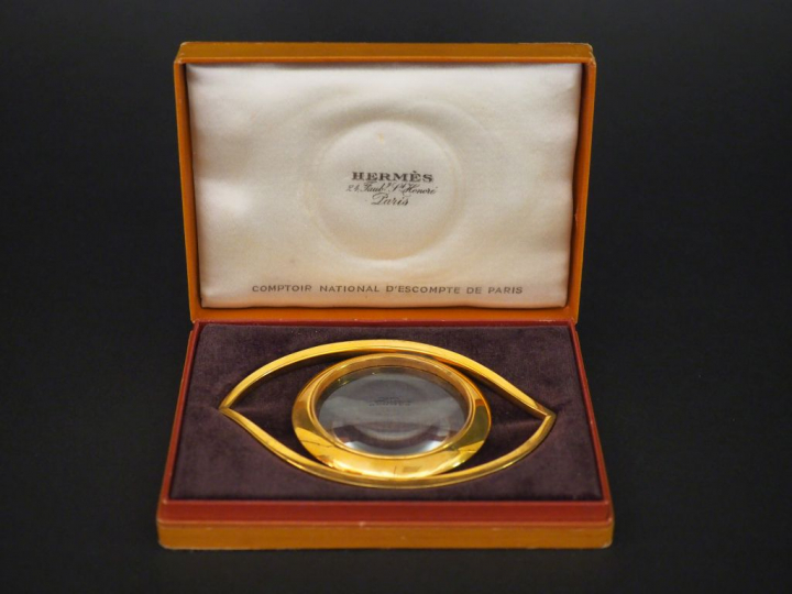 HERMES, Paris Loupe en métal doré en forme d'œil.  Signée. 7 x 10,5 cm