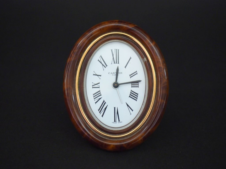 CARTIER,Paris Pendulette de table de forme ovale en laiton doré et imi